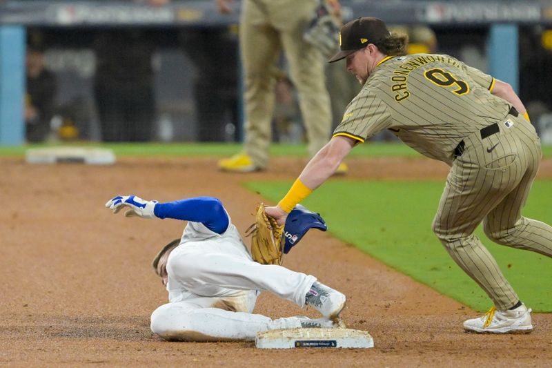 Oct 5, 2024; Los Angeles, California, USA; Los Angeles Dodgers first baseman Freddie Freeman (5) attempts to steal to second base as San Diego Padres second baseman Jake Cronenworth (9) reaches to tag during game one of the NLDS for the 2024 MLB Playoffs at Dodger Stadium. Mandatory Credit: Jayne Kamin-Oncea-Imagn Images