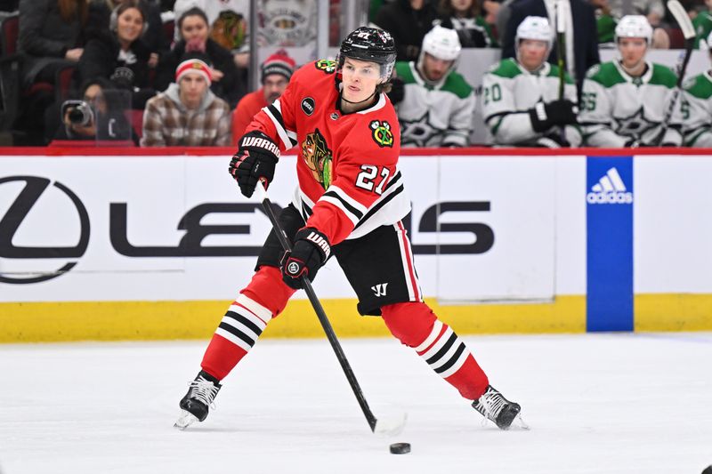 Jan 13, 2024; Chicago, Illinois, USA;  Chicago Blackhawks forward Lukas Reichel (27) passes the puck on the power play in the first period against the Dallas Stars at United Center. Mandatory Credit: Jamie Sabau-USA TODAY Sports