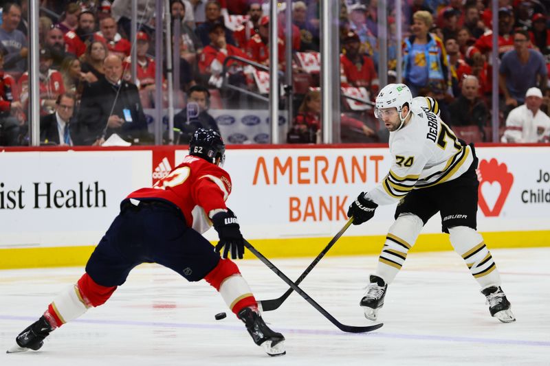 May 6, 2024; Sunrise, Florida, USA; Boston Bruins left wing Jake DeBrusk (74) moves the puck as Florida Panthers defenseman Brandon Montour (62) defends during the first period in game one of the second round of the 2024 Stanley Cup Playoffs at Amerant Bank Arena. Mandatory Credit: Sam Navarro-USA TODAY Sports