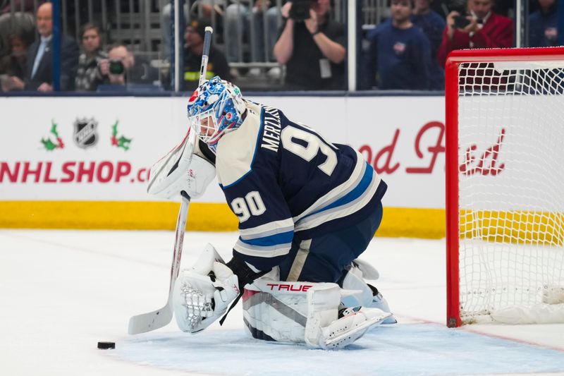 Nov 23, 2024; Columbus, Ohio, USA;  Columbus Blue Jackets goaltender Elvis Merzlikins (90) controls the puck against the Carolina Hurricanes in the first period at Nationwide Arena. Mandatory Credit: Aaron Doster-Imagn Images