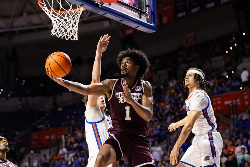 Jan 24, 2024; Gainesville, Florida, USA; Mississippi State Bulldogs forward Tolu Smith (1) attempts a layup over Florida Gators center Micah Handlogten (3) and guard Walter Clayton Jr. (1) during the first half at Exactech Arena at the Stephen C. O'Connell Center. Mandatory Credit: Matt Pendleton-USA TODAY Sports