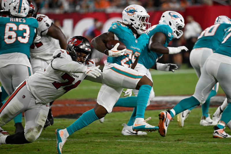 Tampa Bay Buccaneers' Ernest Brown (74) goes after Miami Dolphins running back Jaylen Wright (25) during the second half of a pre season NFL football game, Friday, Aug. 23, 2024, in Tampa, Fla. (AP Photo/Jason Behnken)