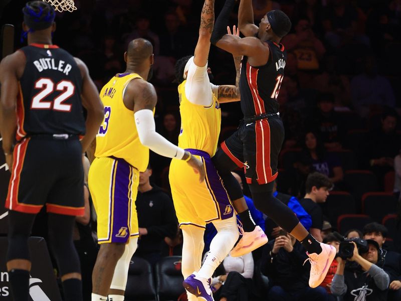 MIAMI, FLORIDA - DECEMBER 04: Bam Adebayo #13 of the Miami Heat drives to the net against Anthony Davis #3 of the Los Angeles Lakers during the first half at Kaseya Center on December 04, 2024 in Miami, Florida.  NOTE TO USER: User expressly acknowledges and agrees that, by downloading and or using this Photograph, user is consenting to the terms and conditions of the Getty Images License Agreement. (Photo by Carmen Mandato/Getty Images)