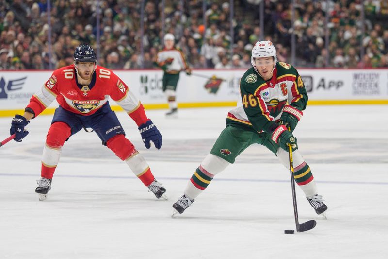 Jan 24, 2026; Saint Paul, Minnesota, USA; Minnesota Wild defenseman Jared Spurgeon (46) skates with the puck as Florida Panthers left wing A.J. Greer (10) applies pressure in the third period at Grand Casino Arena. Mandatory Credit: Matt Blewett-Imagn Images