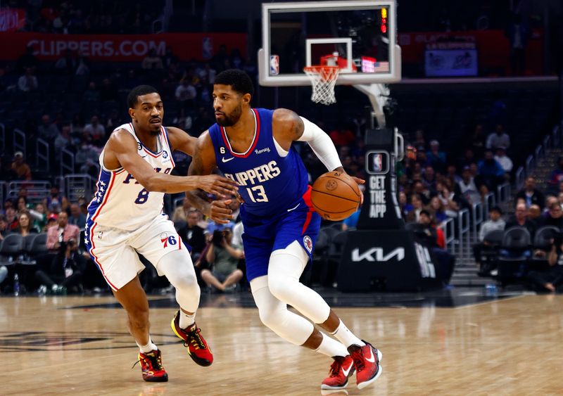 LOS ANGELES, CALIFORNIA - JANUARY 17:  Paul George #13 of the LA Clippers controls the ball against De'Anthony Melton #8 of the Philadelphia 76ers in the first half at Crypto.com Arena on January 17, 2023 in Los Angeles, California.  NOTE TO USER: User expressly acknowledges and agrees that, by downloading and/or using this photograph, user is consenting to the terms and conditions of the Getty Images License Agreement.  (Photo by Ronald Martinez/Getty Images)