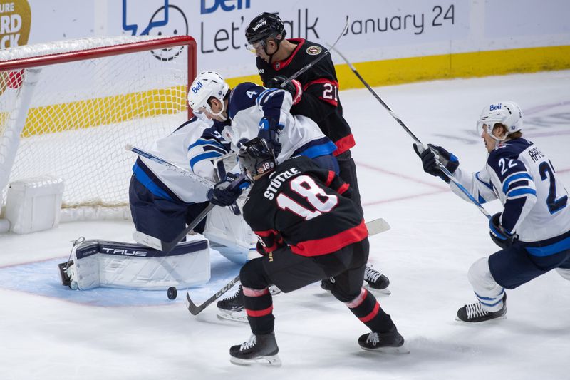 Jan 20, 2024; Ottawa, Ontario, CAN; Ottawa Senators center Tim Stutzle (18) recovers the puck following a save by Winnipeg Jets goalie Connor Hellebuyck (37) in the third period at the Canadian Tire Centre. Mandatory Credit: Marc DesRosiers-USA TODAY Sports