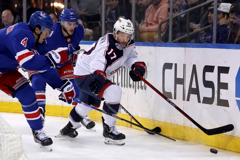 Feb 28, 2024; New York, New York, USA; Columbus Blue Jackets right wing Justin Danforth (17) fights for the puck against New York Rangers defenseman Braden Schneider (4) and center Jonny Brodzinski (22) during the first period at Madison Square Garden. Mandatory Credit: Brad Penner-USA TODAY Sports