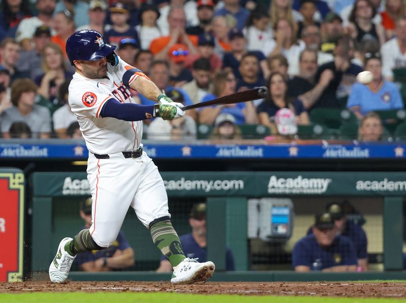 May 18, 2024; Houston, Texas, USA; Houston Astros second baseman Jose Altuve (27) hits a single against the Milwaukee Brewers in the fifth inning at Minute Maid Park. Mandatory Credit: Thomas Shea-USA TODAY Sports