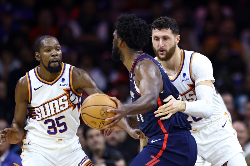 PHILADELPHIA, PENNSYLVANIA - NOVEMBER 04: Kevin Durant #35 and Drew Eubanks #14 of the Phoenix Suns guard Joel Embiid #21 of the Philadelphia 76ers  at the Wells Fargo Center on November 04, 2023 in Philadelphia, Pennsylvania. NOTE TO USER: User expressly acknowledges and agrees that, by downloading and or using this photograph, User is consenting to the terms and conditions of the Getty Images License Agreement. (Photo by Tim Nwachukwu/Getty Images)