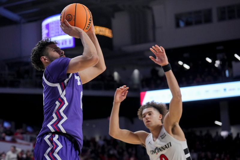 Jan 16, 2024; Cincinnati, Ohio, USA;  TCU Horned Frogs guard Trevian Tennyson (11) attempts a three-point basket against Cincinnati Bearcats guard Dan Skillings Jr. (0) in overtime at Fifth Third Arena. Mandatory Credit: Aaron Doster-USA TODAY Sports