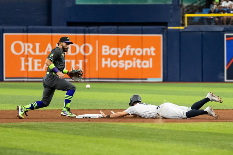 May 11, 2024; St. Petersburg, Florida, USA; New York Yankees shortstop Anthony Volpe (11) slides into second base against Tampa Bay Rays shortstop José Caballero (7) during the fifth inning at Tropicana Field. Mandatory Credit: Matt Pendleton-USA TODAY Sports