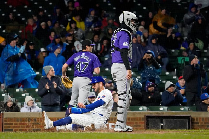 Apr 3, 2024; Chicago, Illinois, USA; Chicago Cubs center fielder Mike Tauchman (40) scores as Colorado Rockies catcher Jacob Stallings (25) stands nearby during the second inning at Wrigley Field. Mandatory Credit: David Banks-USA TODAY Sports