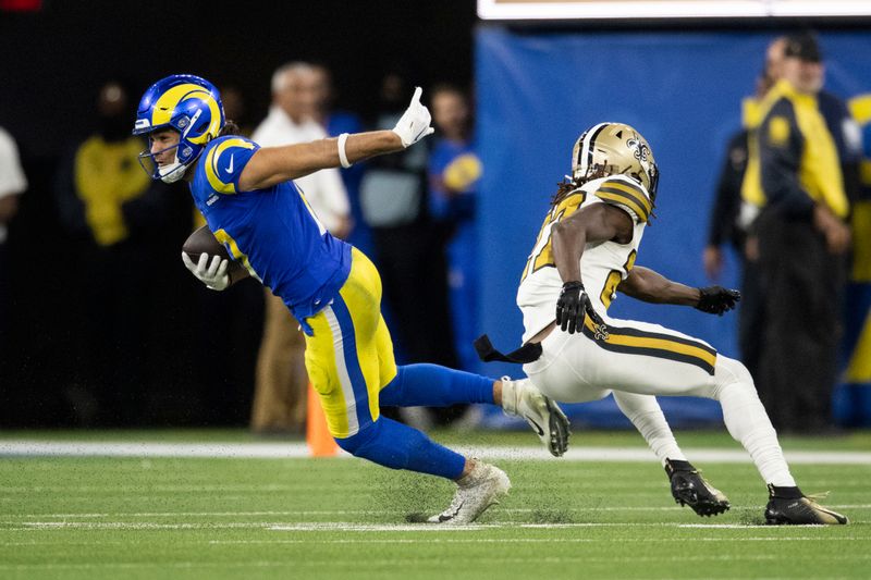 Los Angeles Rams wide receiver Puka Nacua (17) runs with the ball past New Orleans Saints cornerback Isaac Yiadom (27) during an NFL football game, Thursday, Dec. 21, 2023, in Inglewood, Calif. (AP Photo/Kyusung Gong)