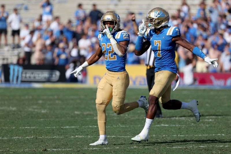 Oct 8, 2022; Pasadena, California, USA;  UCLA Bruins defensive back Azizi Hearn (22) and defensive back Mo Osling III (7) celebrate after stopping the Utah Utes offense during the fourth quarter at Rose Bowl. Mandatory Credit: Kiyoshi Mio-USA TODAY Sports