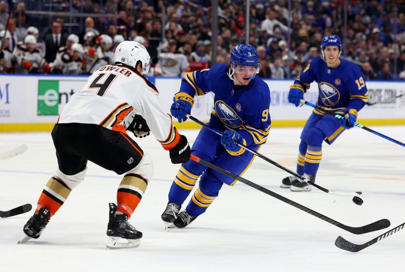 Feb 19, 2024; Buffalo, New York, USA;  Buffalo Sabres left wing Zach Benson (9) flips the puck up ice past Anaheim Ducks defenseman Cam Fowler (4) during the second period at KeyBank Center. Mandatory Credit: Timothy T. Ludwig-USA TODAY Sports