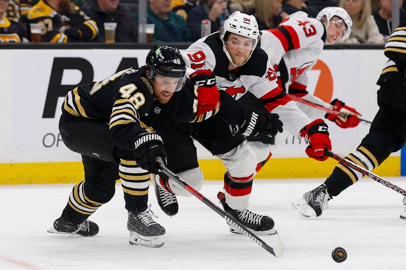 Jan 15, 2024; Boston, Massachusetts, USA; Boston Bruins defenseman Matt Grzelcyk (48) and New Jersey Devils center Dawson Mercer (91) battle for a loose puck during the second period at TD Garden. Mandatory Credit: Winslow Townson-USA TODAY Sports