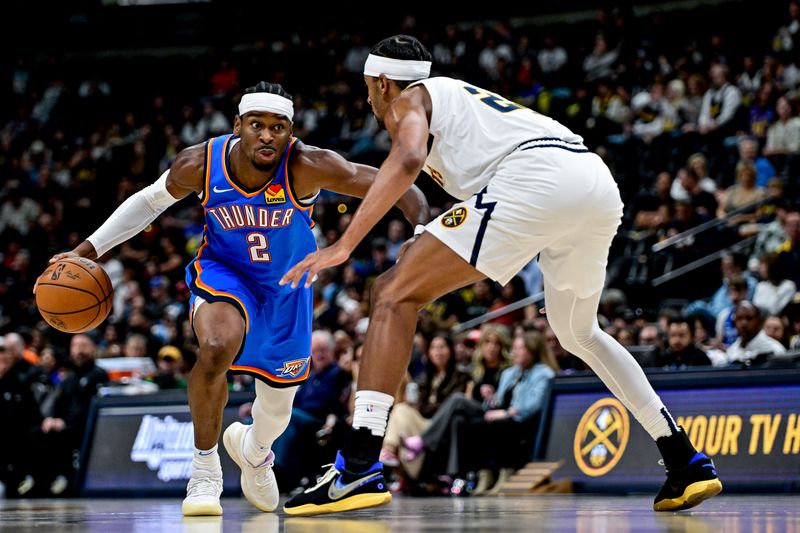 DENVER, COLORADO - OCTOBER 25: Shai Gilgeous-Alexander #2 of the Oklahoma City Thunder is defended by Zeke Nnaji #22 of the Denver Nuggets in the first half at Ball Arena on October 15, 2024 in Denver, Colorado. NOTE TO USER: User expressly acknowledges and agrees that, by downloading and or using this photograph, User is consenting to the terms and conditions of the Getty Images License Agreement. (Photo by Dustin Bradford/Getty Images)