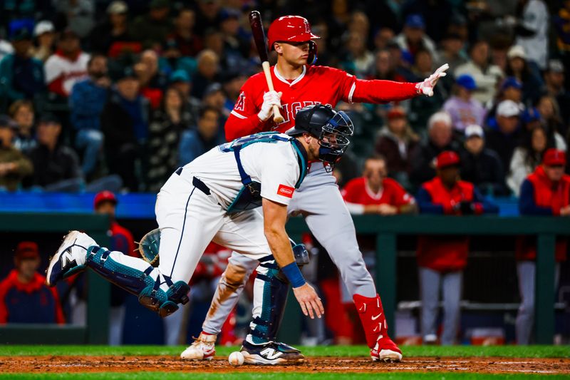 Apr 29, 2025; Seattle, Washington, USA; Los Angeles Angels catcher Logan O'Hoppe (14) signals baserunners to hold while Seattle Mariners catcher Cal Raleigh (29) recovers a pitch in the dirt during the fourth inning at T-Mobile Park. Mandatory Credit: Joe Nicholson-Imagn Images