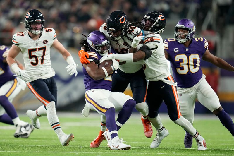 Minnesota Vikings running back Alexander Mattison (2) is tackled by Chicago Bears linebacker Tremaine Edmunds (49) during the first half of an NFL football game, Monday, Nov. 27, 2023, in Minneapolis. (AP Photo/Abbie Parr)