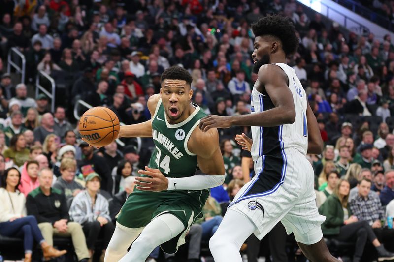 MILWAUKEE, WISCONSIN - DECEMBER 21: Giannis Antetokounmpo #34 of the Milwaukee Bucks is defended by Jonathan Isaac #1 of the Orlando Magic during a game at Fiserv Forum on December 21, 2023 in Milwaukee, Wisconsin. NOTE TO USER: User expressly acknowledges and agrees that, by downloading and or using this photograph, User is consenting to the terms and conditions of the Getty Images License Agreement. (Photo by Stacy Revere/Getty Images)