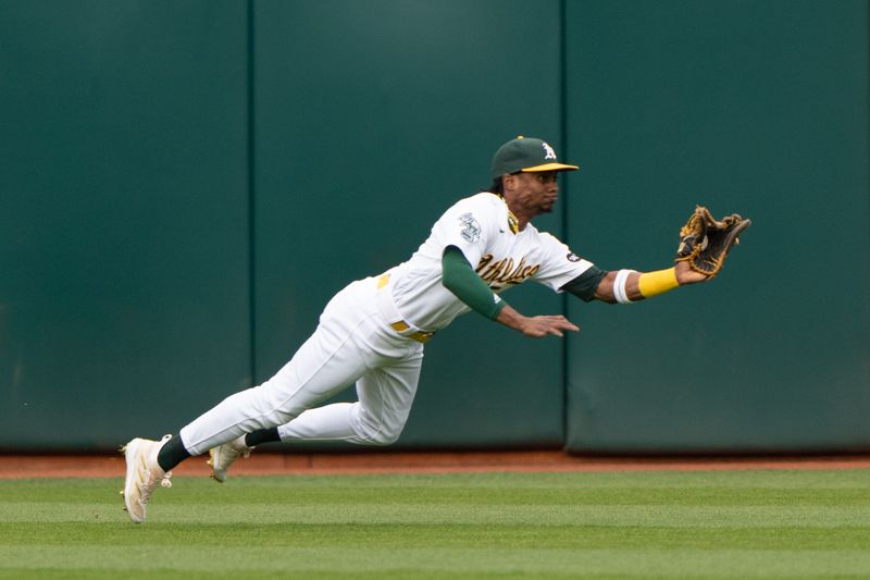 Jun 28, 2023; Oakland, California, USA;  Oakland Athletics center fielder Esteury Ruiz (1) dives for the ball during the first inning against the New York Yankees at Oakland-Alameda County Coliseum. Mandatory Credit: Stan Szeto-USA TODAY Sports