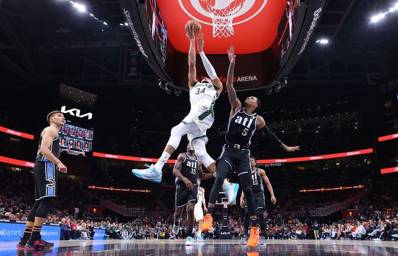 ATLANTA, GEORGIA - MARCH 30:  Giannis Antetokounmpo #34 of the Milwaukee Bucks attacks the basket against Dejounte Murray #5 of the Atlanta Hawks during the fourth quarter at State Farm Arena on March 30, 2024 in Atlanta, Georgia.  NOTE TO USER: User expressly acknowledges and agrees that, by downloading and/or using this photograph, user is consenting to the terms and conditions of the Getty Images License Agreement.  (Photo by Kevin C. Cox/Getty Images)