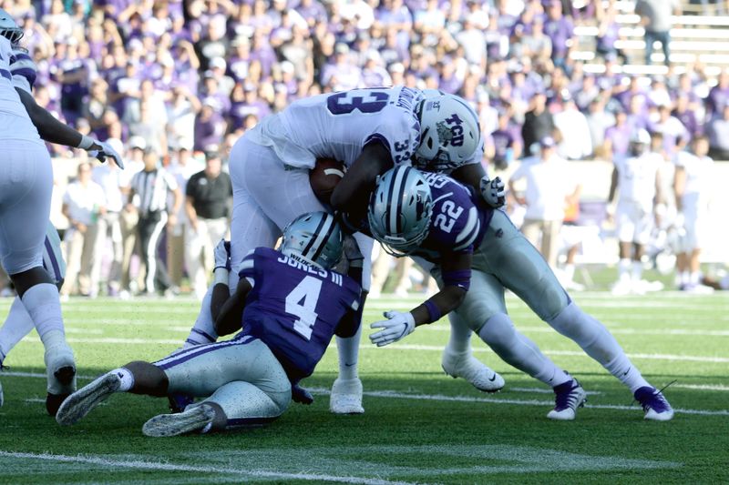 Oct 19, 2019; Manhattan, KS, USA; TCU Horned Frogs running back Sewo Olonilua (33) is tackled by Kansas State Wildcats defensive back Wayne Jones (4) and linebacker Daniel Green (22) during the fourth quarter of a game at Bill Snyder Family Stadium. Mandatory Credit: Scott Sewell-USA TODAY Sports