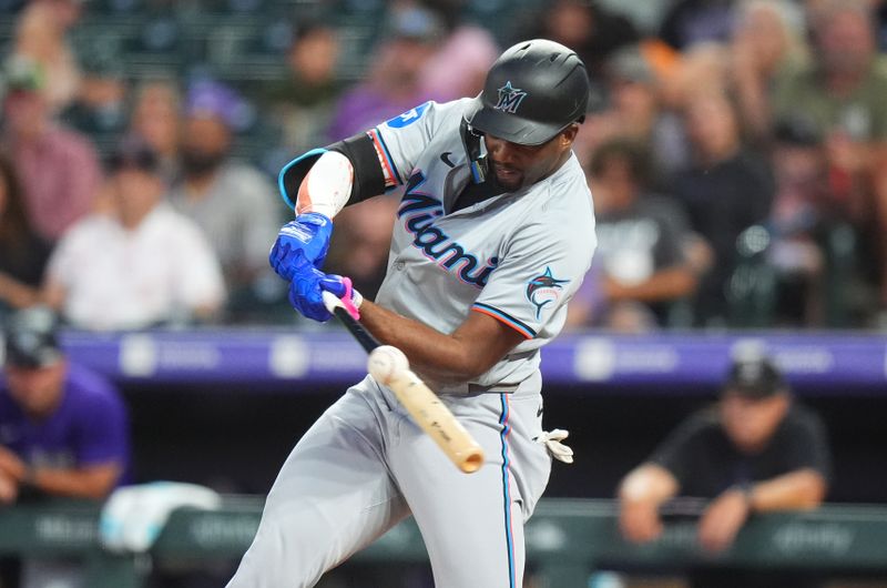 Aug 26, 2024; Denver, Colorado, USA; Miami Marlins outfielder Jesus Sanchez (12) hits a two run single in the fifth inning against the Colorado Rockies at Coors Field. Mandatory Credit: Ron Chenoy-USA TODAY Sports