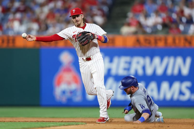 Jul 9, 2024; Philadelphia, Pennsylvania, USA; Philadelphia Phillies second base Bryson Stott (5) throws for a double play after tagging out Los Angeles Dodgers second base Gavin Lux (9) during the eighth inning at Citizens Bank Park. Mandatory Credit: Bill Streicher-USA TODAY Sports