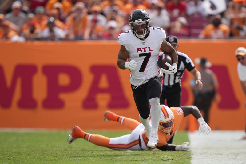 Atlanta Falcons running back Bijan Robinson (7) rushes with the ball after getting past Tampa Bay Buccaneers linebacker K.J. Britt (52) during an NFL football game, Sunday, Oct. 27, 2024, in Tampa, Fla. (AP Photo/Peter Joneleit)
