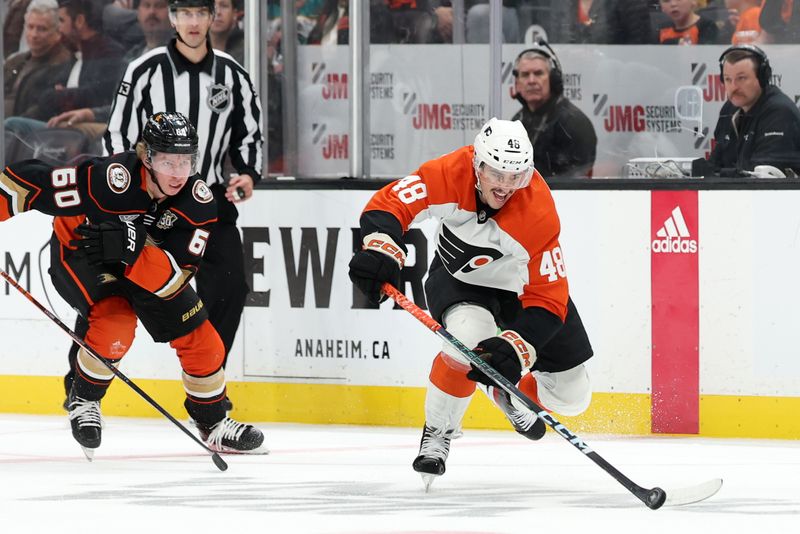 Nov 10, 2023; Anaheim, California, USA; Philadelphia Flyers center Morgan Frost (48) controls the puck past Anaheim Ducks defenseman Jackson LaCombe (60) during the third period at Honda Center. Mandatory Credit: Kiyoshi Mio-USA TODAY Sports