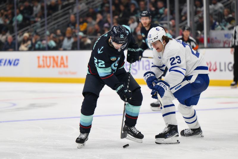 Jan 21, 2024; Seattle, Washington, USA; Seattle Kraken right wing Oliver Bjorkstrand (22) and Toronto Maple Leafs left wing Matthew Knies (23) fight for the puck during the second period at Climate Pledge Arena. Mandatory Credit: Steven Bisig-USA TODAY Sports