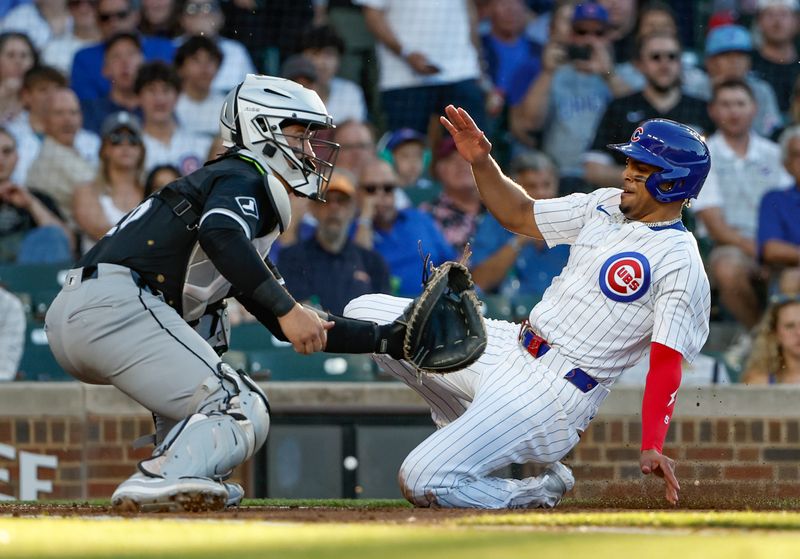 Jun 5, 2024; Chicago, Illinois, USA; Chicago Cubs third baseman Christopher Morel (5) slides to score as Chicago White Sox catcher Martín Maldonado (15) waits for the ball during the second inning at Wrigley Field. Mandatory Credit: Kamil Krzaczynski-USA TODAY Sports