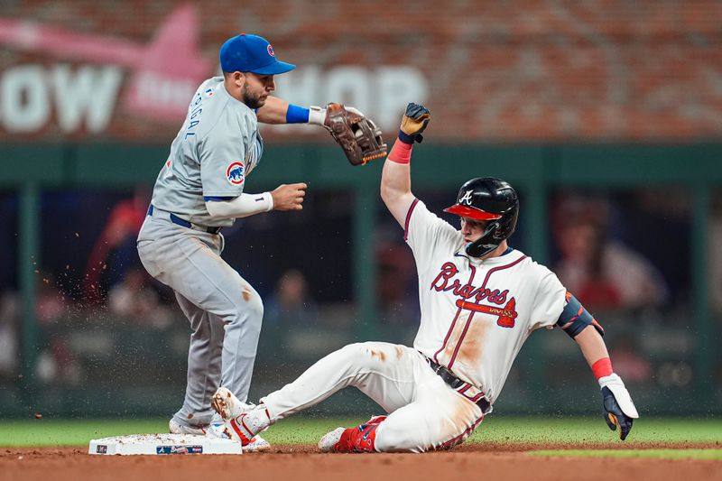 May 15, 2024; Cumberland, Georgia, USA; Atlanta Braves third baseman Zack Short (59) slides into second base next to Chicago Cubs second baseman Nick Madrigal (1) after hitting a double to drive in a run during the seventh inning at Truist Park. Mandatory Credit: Dale Zanine-USA TODAY Sports