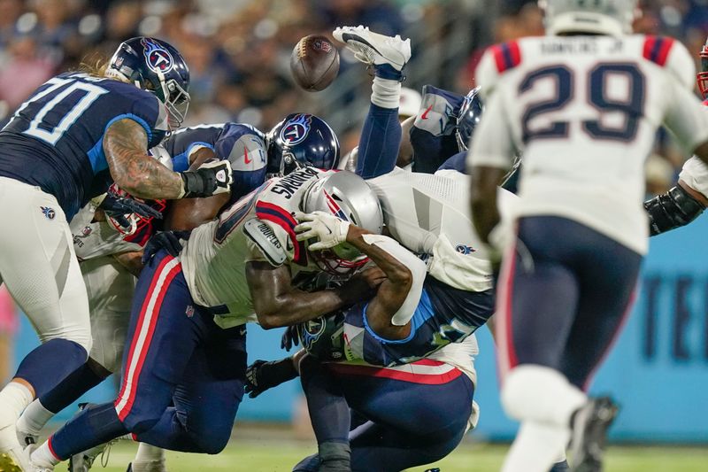 Tennessee Titans running back Julius Chestnut fumbles as he is hit by New England Patriots defensive end Jeremiah Pharms Jr. in the first half of an NFL preseason football game Friday, Aug. 25, 2023, in Nashville, Tenn. (AP Photo/George Walker IV)