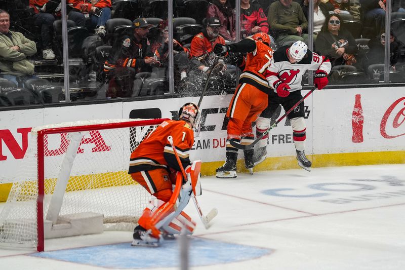 Nov 2, 2025; Anaheim, California, USA; New Jersey Devils center Dawson Mercer (91) checks Anaheim Ducks defenseman Ian Moore (74) during the third period at Honda Center. Mandatory Credit: Corinne Votaw-Imagn Images