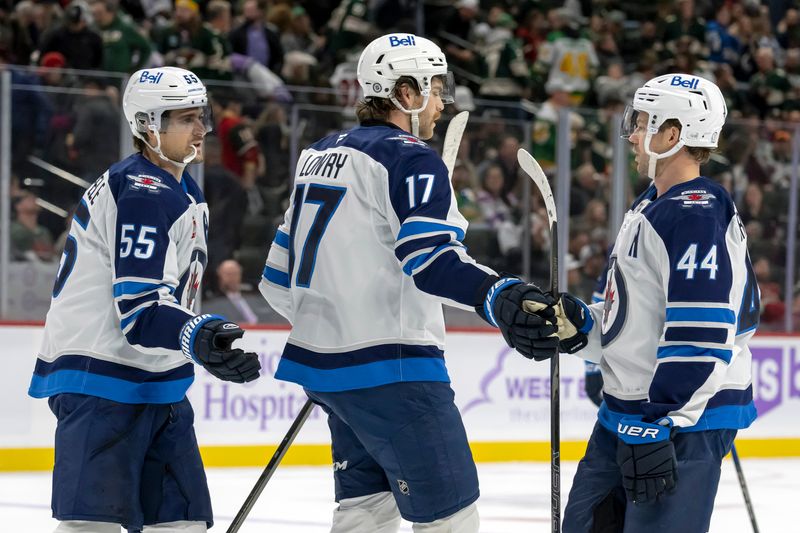 Nov 25, 2024; Saint Paul, Minnesota, USA;  Winnipeg Jets forward Adam Lowry (17) celebrates his empty net goal against the Minnesota Wild with forward Mark Scheifele (55) and defenseman Josh Morrissey (44) during the third period at Xcel Energy Center. Mandatory Credit: Nick Wosika-Imagn Images