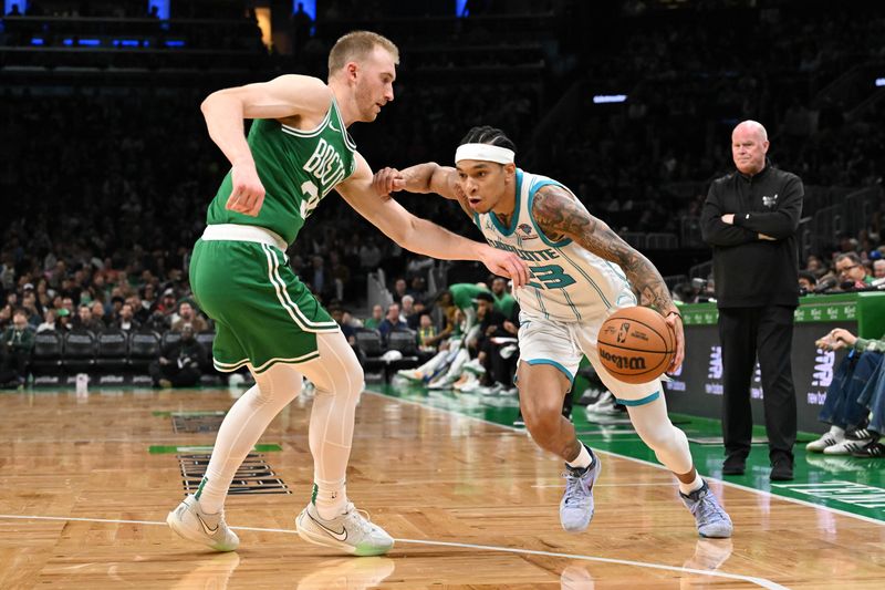 BOSTON, MASSACHUSETTS - APRIL 12: Tre Mann #23 of the Charlotte Hornets drives to the basket against Sam Hauser #30 of the Boston Celtics during the third quarter at the TD Garden on April 12, 2024 in Boston, Massachusetts. NOTE TO USER: User expressly acknowledges and agrees that, by downloading and or using this photograph, User is consenting to the terms and conditions of the Getty Images License Agreement. (Photo by Brian Fluharty/Getty Images)