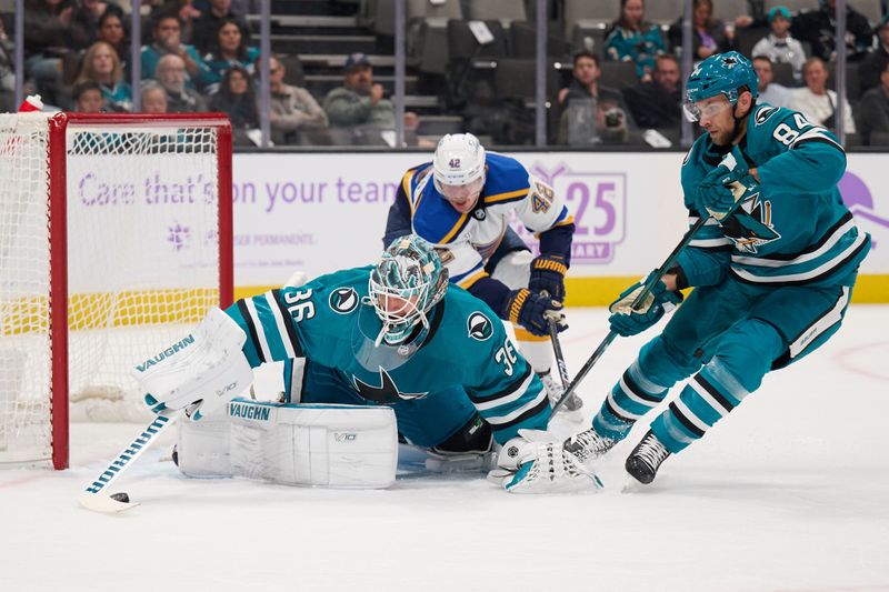 Nov 16, 2023; San Jose, California, USA; San Jose Sharks goaltender Kaapo Kahkonen (36) extends his stick to control a loose puck with defenseman Jan Rutta (84) against St. Louis Blues right wing Kasperi Kapanen (42) during the first period at SAP Center at San Jose. Mandatory Credit: Robert Edwards-USA TODAY Sports