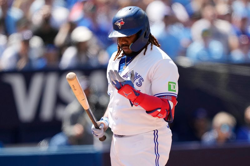 Jul 30, 2023; Toronto, Ontario, CAN; Toronto Blue Jays first baseman Vladimir Guerrero Jr. (27) looks at his hands during an at bat against the Los Angeles Angels in the eighth inning at Rogers Centre. Mandatory Credit: John E. Sokolowski-USA TODAY Sports