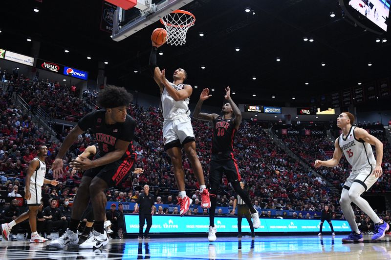 Jan 6, 2024; San Diego, California, USA; San Diego State Aztecs forward Jaedon LeDee (13) goes to the basket past UNLV Rebels forward Kalib Boone (10) during the second half at Viejas Arena. Mandatory Credit: Orlando Ramirez-USA TODAY Sports