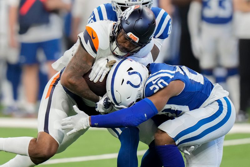 Denver Broncos wide receiver Tim Patrick (12) carries the ball against Indianapolis Colts safety Nick Cross (20) during the first quarter of a preseason NFL football game, Sunday, Aug. 11, 2024, in Westfield, Ind. (AP Photo/AJ Mast)