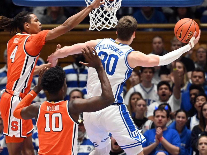 Jan 2, 2024; Durham, North Carolina, USA; Duke Blue Devils center Kyle Filipowski (30) lays the ball up in front of Syracuse Orange forward Chris Bell (4) during the first half at Cameron Indoor Stadium. Mandatory Credit: Rob Kinnan-USA TODAY Sports