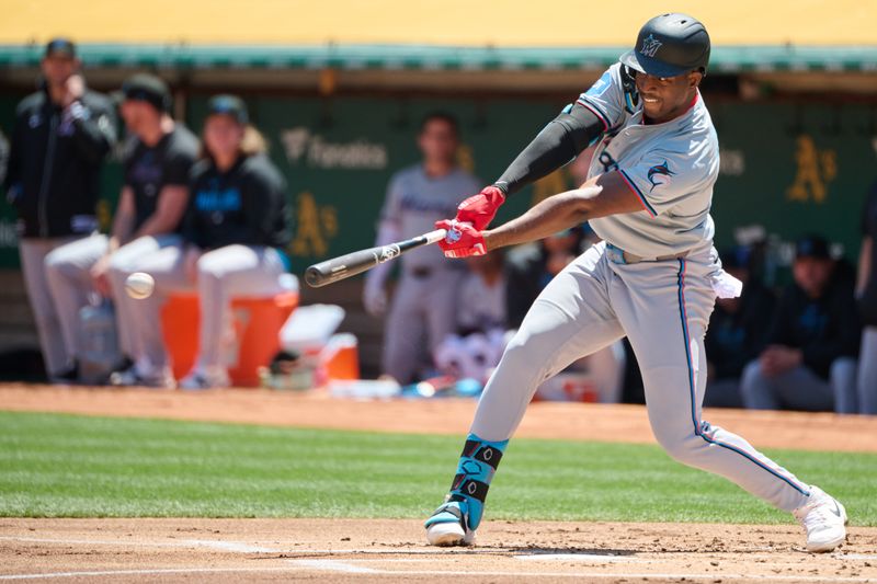 May 5, 2024; Oakland, California, USA; Miami Marlins outfielder Jesus Sanchez (12) hits an RBI single against the Oakland Athletics during the first inning at Oakland-Alameda County Coliseum. Mandatory Credit: Robert Edwards-USA TODAY Sports