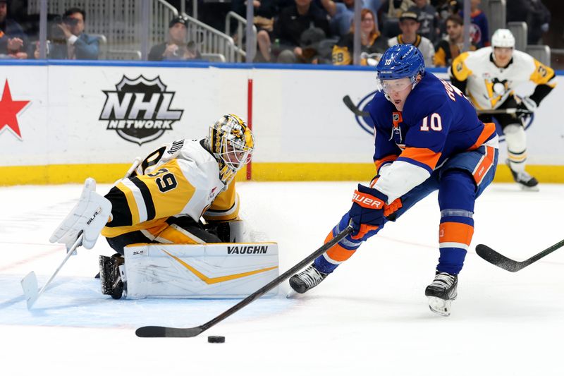 Nov 5, 2024; Elmont, New York, USA; New York Islanders right wing Simon Holmstrom (10) plays the puck against Pittsburgh Penguins goaltender Alex Nedeljkovic (39) during the second period at UBS Arena. Mandatory Credit: Brad Penner-Imagn Images