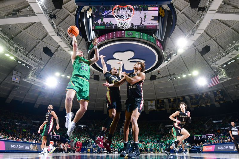 Jan 17, 2023; South Bend, Indiana, USA; Notre Dame Fighting Irish guard Dane Goodwin (23) goes up for a shot as Florida State Seminoles guard Caleb Mills (4) and forward Cam Corhen (3) defend in the second half at the Purcell Pavilion. Mandatory Credit: Matt Cashore-USA TODAY Sports