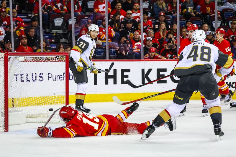 Oct 14, 2025; Calgary, Alberta, CAN; Vegas Golden Knights center Tomas Hertl (48) scores an empty net goal as Calgary Flames defenseman Zayne Parekh (19) defends during the third period at Scotiabank Saddledome. Mandatory Credit: Sergei Belski-Imagn Images