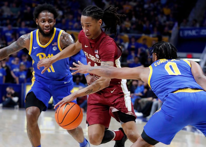 Jan 21, 2023; Pittsburgh, Pennsylvania, USA;  Florida State Seminoles guard Caleb Mills (4) drives to the basket between Pittsburgh Panthers guard Jamarius Burton (11) and guard Nelly Cummings (0) during the first half at the Petersen Events Center. Mandatory Credit: Charles LeClaire-USA TODAY Sports