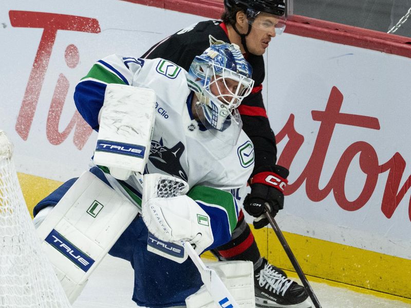 Jan 13, 2026; Ottawa, Ontario, CAN; Vancouver Canucks goalie Kevin Lankinen (32) moves the puck against Ottawa Senators center Nick Cousins (21) during the third period at the Canadian Tire Centre. Mandatory Credit: Marc DesRosiers-IMAGN Images