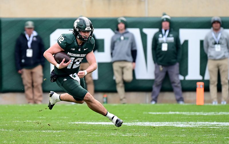 Nov 4, 2023; East Lansing, Michigan, USA;  Michigan State Spartans quarterback Katin Houser (12) sprints upfield in the fourth quarter against the Nebraska Cornhuskers at Spartan Stadium. Mandatory Credit: Dale Young-USA TODAY Sports